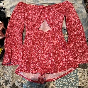 xs red top with flower prints, flare sleeves and open stomach area with a knot
